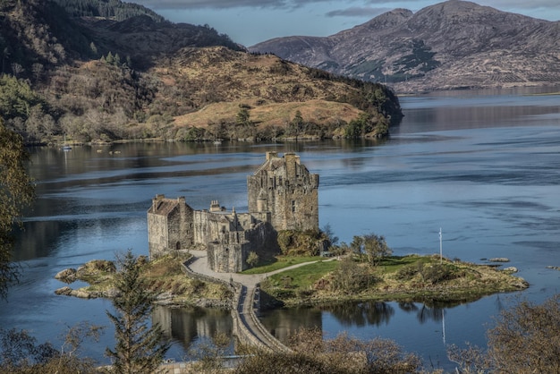 A panoramic view of the Scottish Highlands, showcasing its rugged mountains, lochs, and historic castles. The image evokes a sense of wild beauty and historical significance.