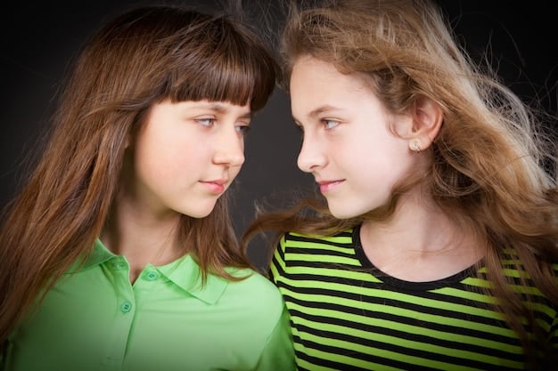 A close-up shot of two teenage friends consoling each other, showcasing their vulnerability and the importance of friendship during difficult times. The background is blurred, focusing attention on their emotional connection.
